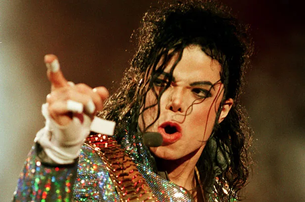 Ο Michael Jackson σε συναυλία με λαμπερό κοστούμι και μικρόφωνο.