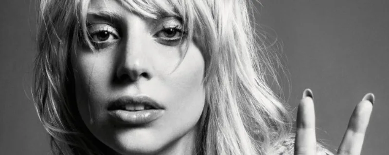 Ασπρόμαυρο κοντινό πορτρέτο της Lady Gaga με ξανθά μαλλιά και αφέλειες.
