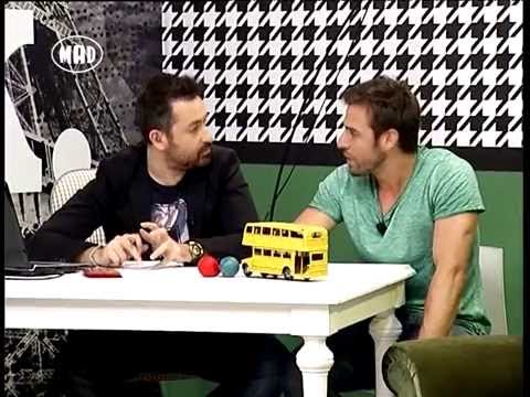 Ο Θέμης Γεωργαντάς και ο Πάνος Βλάχος σε τηλεοπτικό πλατό με ένα κίτρινο λεωφορείο-παιχνίδι.
