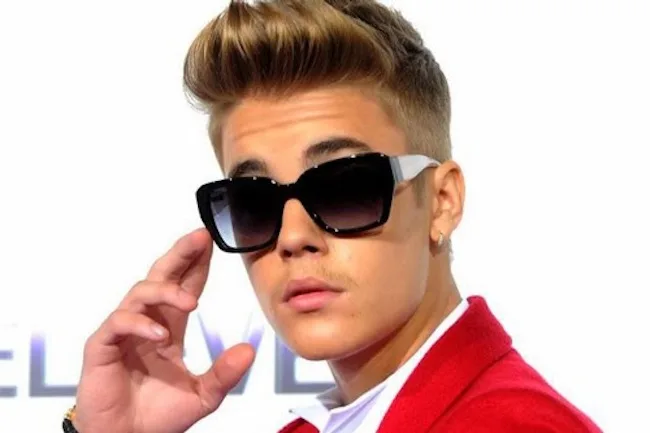 Ο Justin Bieber με μαύρα γυαλιά ηλίου και κόκκινο σακάκι.