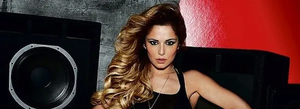 Η Cheryl Cole ποζάρει μπροστά από ηχεία.