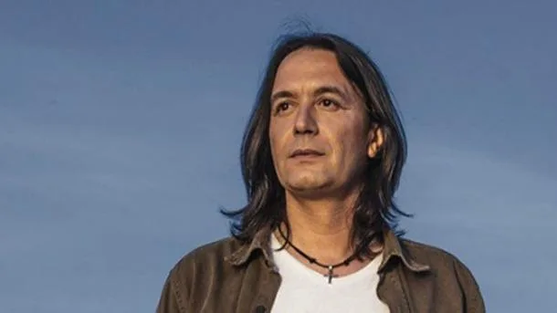 Ο Γιάννης Κότσιρας σε εξωτερικό χώρο με φόντο τον ουρανό.