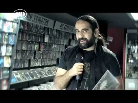 Παρουσιαστής με μικρόφωνο σε δισκοπωλείο με heavy metal δίσκους.