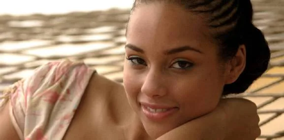 Η Alicia Keys χαμογελάει ξαπλωμένη σε μια αιώρα.