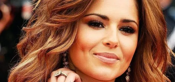Κοντινό πλάνο της Cheryl Cole με κυματιστά καστανά μαλλιά και έντονο μακιγιάζ.