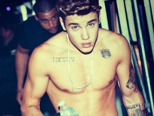Ο Justin Bieber χωρίς μπλούζα δείχνοντας τα τατουάζ του.