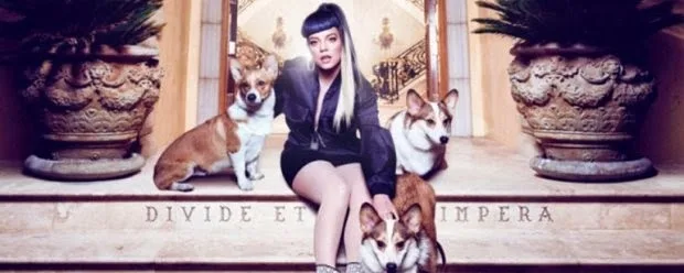 Η Lily Allen κάθεται σε σκαλιά ανάμεσα σε τρία σκυλιά κόργκι.