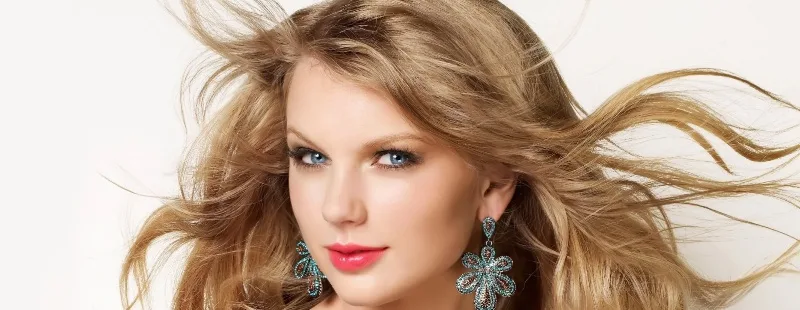 Η Taylor Swift με ξανθά μαλλιά και μεγάλα σκουλαρίκια.
