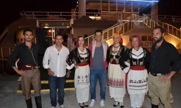 Ο Σάκης Ρουβάς ποζάρει με ομάδα ανθρώπων σε παραδοσιακές κρητικές στολές.