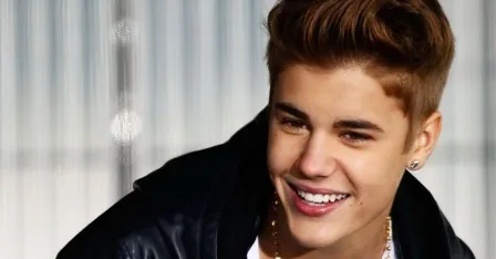 Ο Justin Bieber χαμογελάει φορώντας μαύρο δερμάτινο μπουφάν.