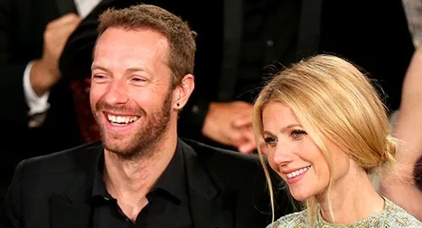 Ο Chris Martin και η Gwyneth Paltrow χαμογελούν σε εκδήλωση.