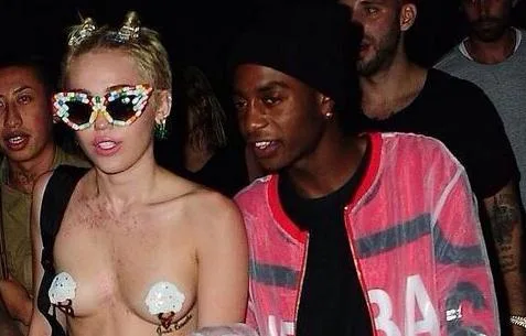 Η Miley Cyrus με πολύχρωμα γυαλιά ηλίου και ιδιαίτερα αξεσουάρ σε βραδινή έξοδο.