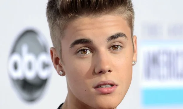 Κοντινό πορτρέτο του Justin Bieber σε κόκκινο χαλί.