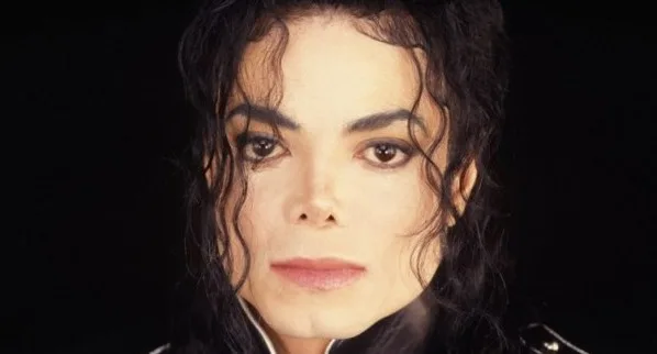 Κοντινό πορτρέτο του Michael Jackson με μαύρο φόντο.