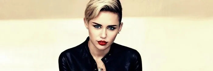 Η Miley Cyrus με κοντό ξανθό μαλλί και μαύρο δερμάτινο τζάκετ.
