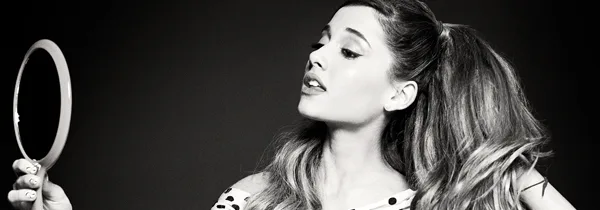 Η Ariana Grande κοιτάζεται σε έναν καθρέφτη σε ασπρόμαυρη φωτογραφία.