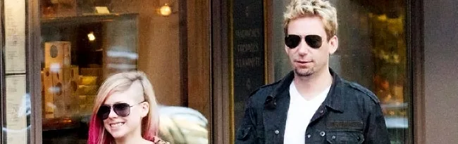 Η Avril Lavigne και ο Chad Kroeger περπατούν στο δρόμο φορώντας γυαλιά ηλίου.