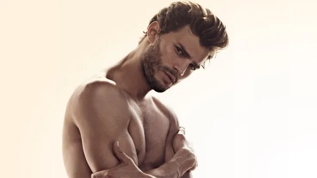 Ο Jamie Dornan ποζάρει ημίγυμνος με σταυρωμένα χέρια.