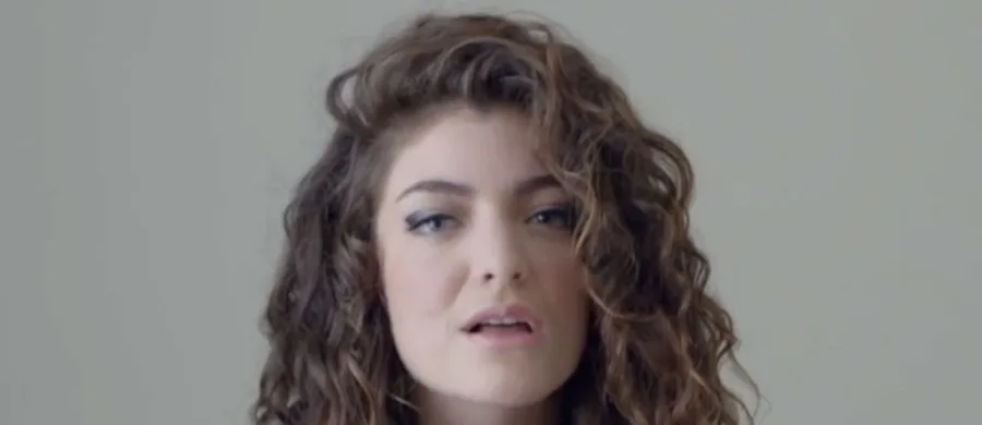 Η Lorde με σγουρά μαλλιά σε κοντινό πλάνο.