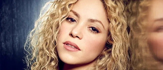 Κοντινό πορτρέτο της Shakira με ξανθά σγουρά μαλλιά.