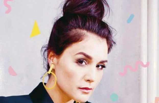Η Jessie Ware με ψηλό κότσο και κίτρινα σκουλαρίκια.