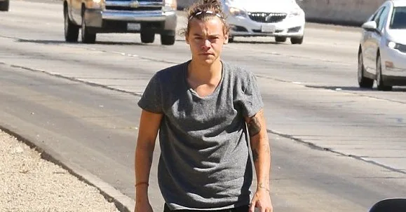 Ο Harry Styles περπατάει στην άκρη ενός δρόμου στο Λος Άντζελες.