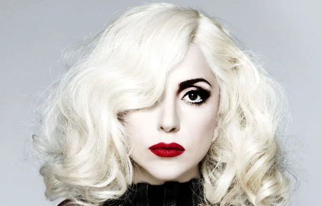 Η Lady Gaga με πλατινέ κυματιστά μαλλιά, έντονο μακιγιάζ στα μάτια και κόκκινο κραγιόν.