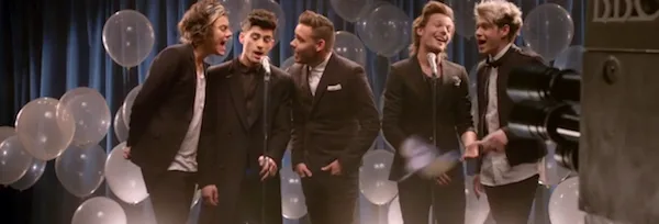 Οι One Direction τραγουδούν μπροστά από λευκά μπαλόνια.