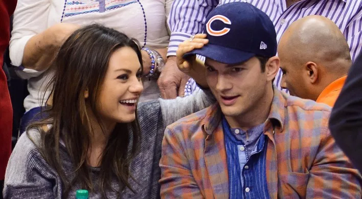 Η Mila Kunis και ο Ashton Kutcher σε κερκίδες γηπέδου.