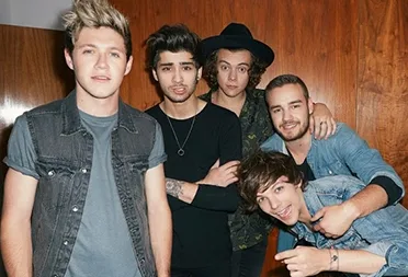 Το συγκρότημα One Direction ποζάρει σε εσωτερικό χώρο.