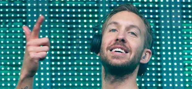 Ο Calvin Harris με ακουστικά μπροστά από φωτιζόμενο φόντο.