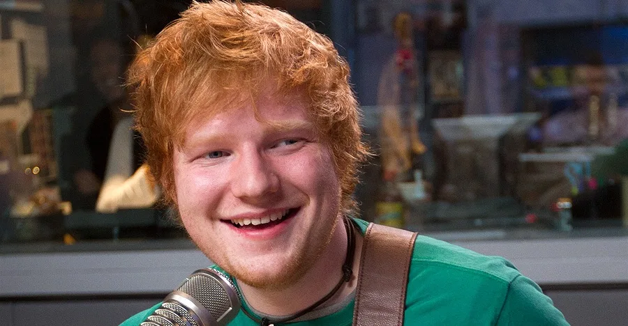 Ο Ed Sheeran χαμογελάει σε ραδιοφωνικό στούντιο.