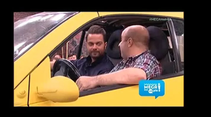 Ο Ηλίας Βρεττός και ο Μάρκος Σεφερλής μέσα σε κίτρινο αυτοκίνητο.