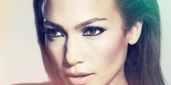 Κοντινό πορτρέτο της Jennifer Lopez με έντονο μακιγιάζ στα μάτια.
