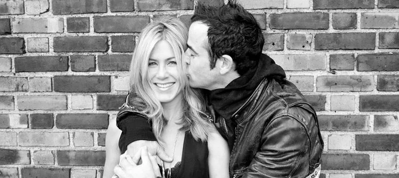 Η Jennifer Aniston και ο Justin Theroux σε ασπρόμαυρη φωτογραφία μπροστά από τοίχο με τούβλα.