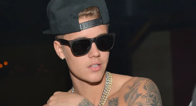 Ο Justin Bieber με μαύρο καπέλο, γυαλιά ηλίου και τατουάζ.