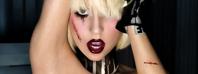 Κοντινό πλάνο της Lady Gaga με εκκεντρικό μακιγιάζ και ξανθά μαλλιά.