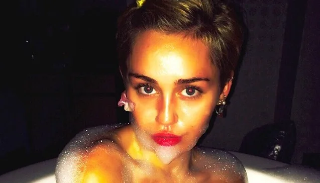 Η Miley Cyrus σε κοντινό πλάνο μέσα σε μπανιέρα με αφρούς.