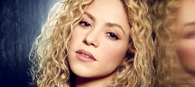 Κοντινό πορτρέτο της Shakira με ξανθά σγουρά μαλλιά.