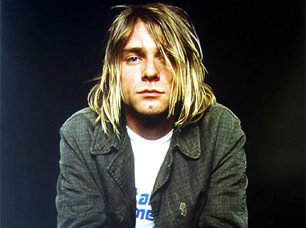 Ο Kurt Cobain με ξανθά μαλλιά και γκρι σακάκι.