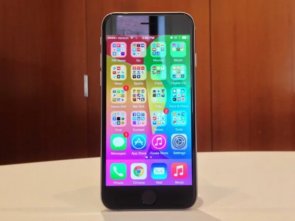 Ένα iPhone 6 με αναμμένη την οθόνη σε ξύλινο φόντο.