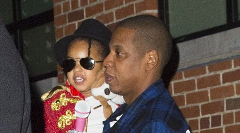 Ο Jay-Z κρατάει την κόρη του Blue Ivy, η οποία είναι ντυμένη ως Michael Jackson.