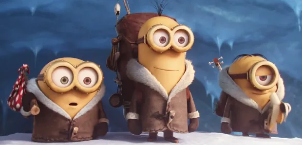 Τρία Minions με χειμερινά παλτό σε χιονισμένο τοπίο.