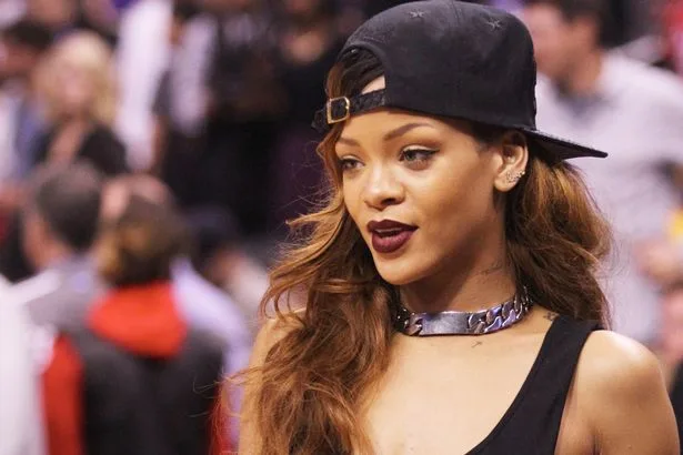 Η Rihanna με μαύρο καπέλο, σκούρο κραγιόν και ασημένιο κολιέ.