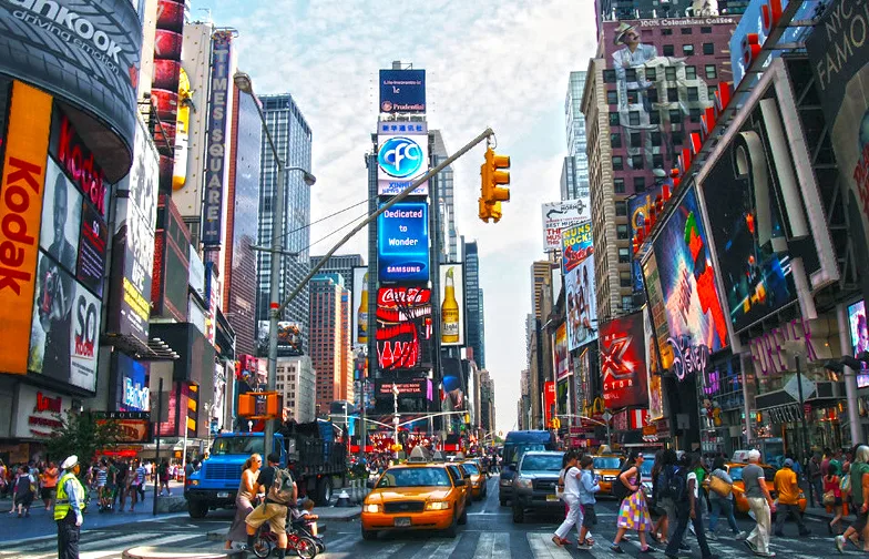Πολυσύχναστη Times Square στη Νέα Υόρκη με κίτρινα ταξί και διαφημιστικές πινακίδες.