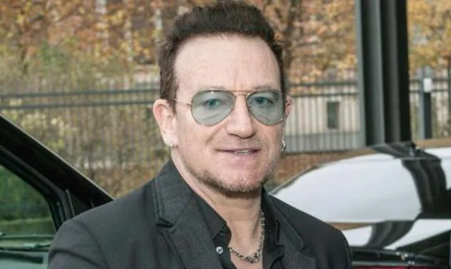Ο Bono των U2 με γυαλιά ηλίου και μαύρο σακάκι.