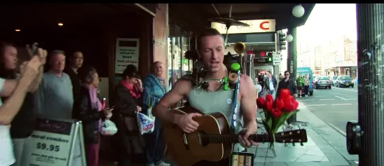 Ο Chris Martin των Coldplay παίζει κιθάρα στο δρόμο ως πλανόδιος μουσικός.