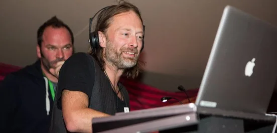 Ο Thom Yorke των Radiohead με ακουστικά μπροστά από ένα laptop.