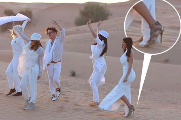 Η Kim Kardashian με λευκό φόρεμα και ψηλοτάκουνα πέδιλα στην έρημο.