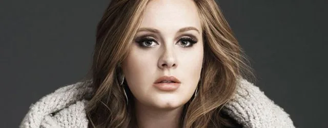 Η Adele με πλεκτό πουλόβερ και έντονο μακιγιάζ στα μάτια.